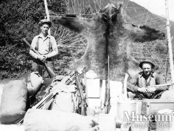 Jim Stanton with gear and bear hide, Knight Inlet, B.C.